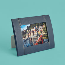 Load image into Gallery viewer, High-end leather picture frame with white contrast stitching. Holds 5x7" photo. Navy blue leather shown, standing horizontally.