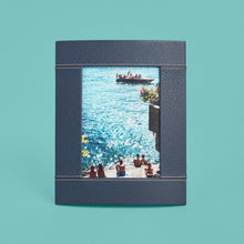 Load image into Gallery viewer, High-end leather picture frame with white contrast stitching. Holds 5x7" photo. Navy blue leather shown, standing vertically.