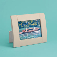 Load image into Gallery viewer, High-end leather picture frame with white contrast stitching. Holds 5x7" photo. Cream / white leather shown, standing horizontally.