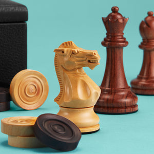 High-end chess set, close up showing hand-carved wooden pieces. Black leather board shown in background.