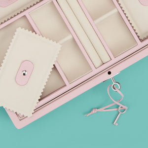 Luxury leather jewelry box, pink / rose color, with lock and key, close up shot to show detail of compartments and trays