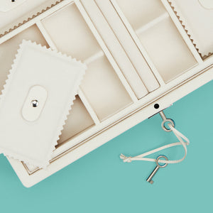 Luxury leather jewelry box, white / cream color, with lock and key, close up shot to show detail of compartments and trays