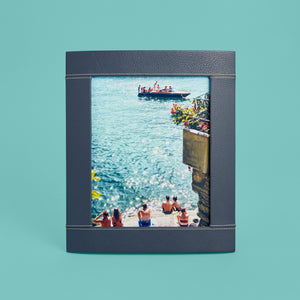 Navy blue leather picture frame with white stitching detail, holds 8x10" photo, standing vertically