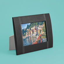 Load image into Gallery viewer, High-end leather picture frame with white contrast stitching. Holds 5x7&quot; photo. Black leather shown, standing horizontally.
