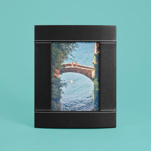 High-end leather picture frame with white contrast stitching. Holds 5x7" photo. Black leather shown, standing vertically.