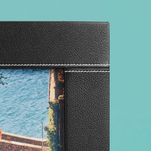 Load image into Gallery viewer, High-end leather picture frame with white contrast stitching. Holds 5x7&quot; photo. Black leather shown, close up of corner shown.
