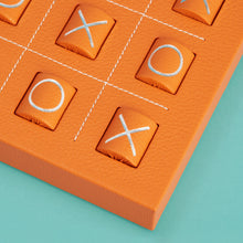 Load image into Gallery viewer, Luxury leather tic tac toe board with white stitching. Shown in orange leather. Close-up of corner shown to highlight high-quality leather and stitching detail.

